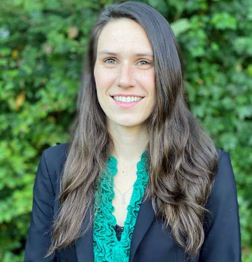 Headshot of Chloe Richard, a graduate student from the University at Buffalo, standing against a mosaic background while smiling.