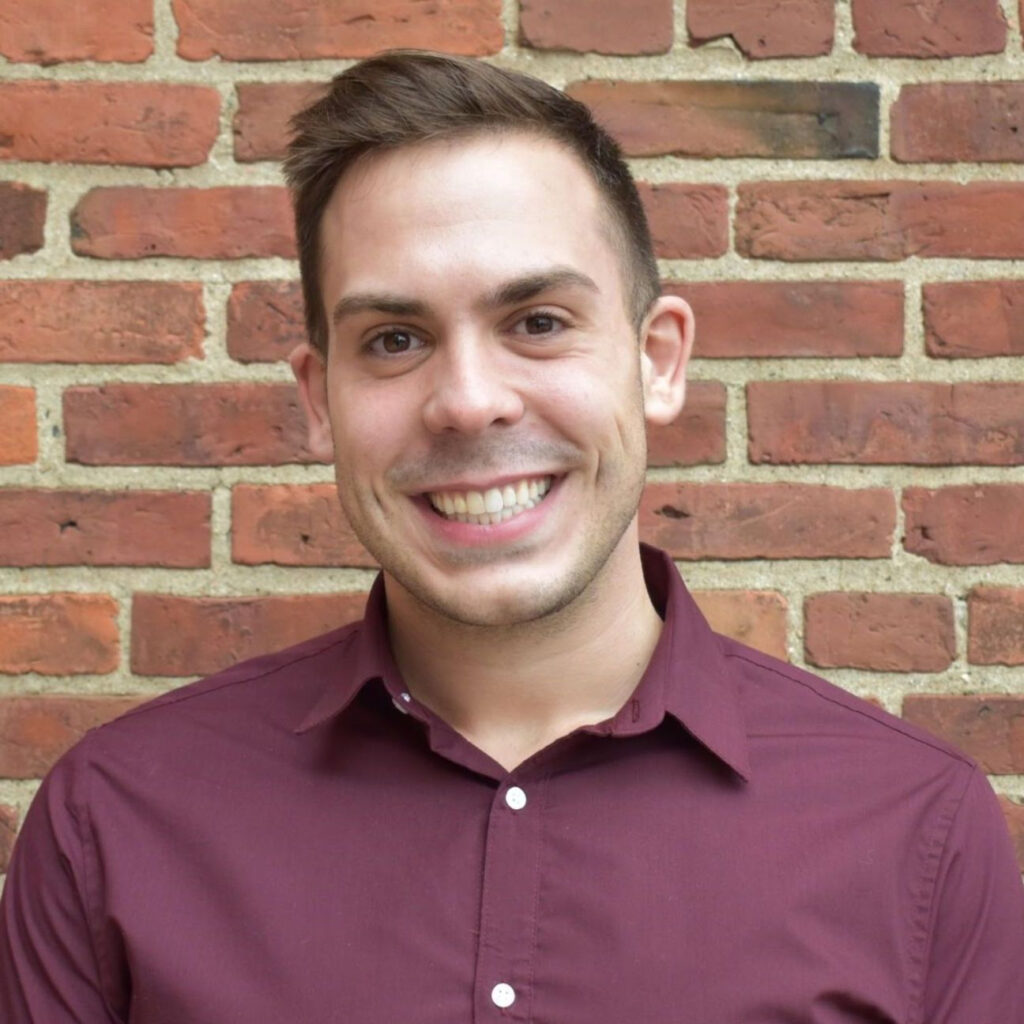 Benjamin W. Katz, a clinical psychology researcher at the University of Wisconsin-Milwaukee, smiling in a professional headshot against a brick wall, wearing a maroon button-up shirt.