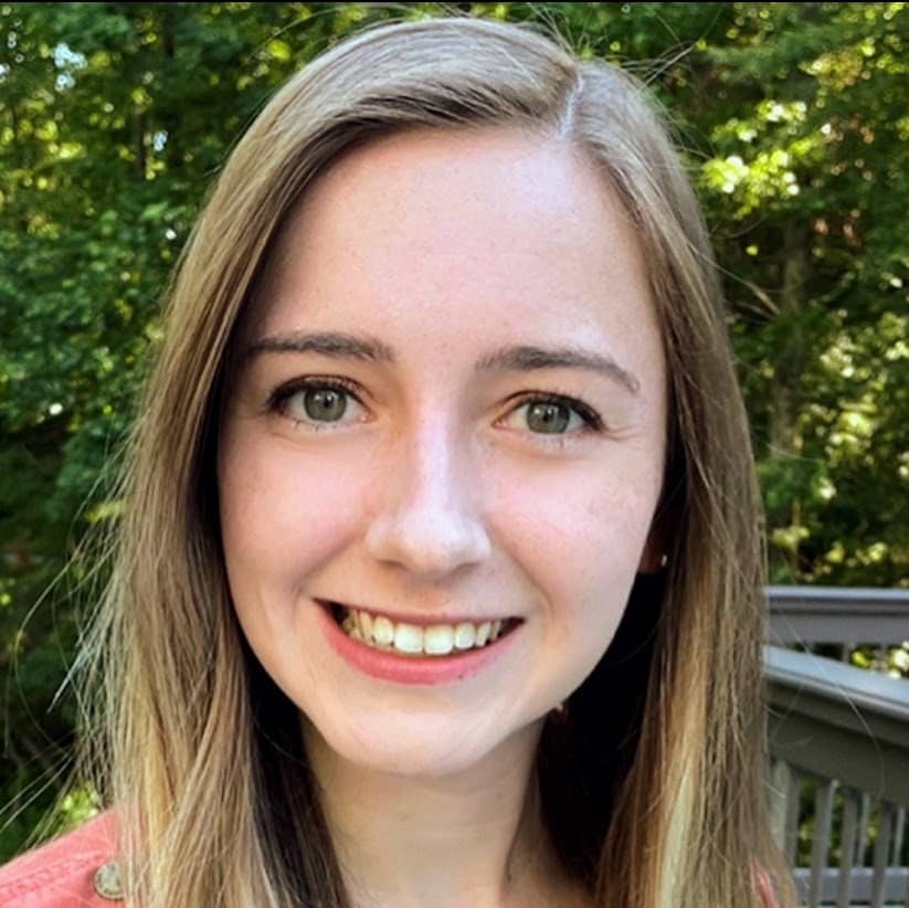 Professional headshot of Kendall Poovey, a graduate student at the University of South Florida, smiling outdoors in a green blazer.